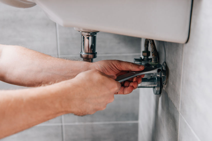 Plumber from Pros Plumbing working on sink