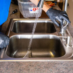 man testing kitchen sink to make sure it works correctly