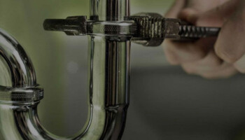plumber screwing together pipes